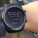 A wrist with a smartwatch on it. The smartwatch has an alert that says "Car honk, 98%, Loud, 101 dB" It also has options to snooze the alert for 10 minutes or open in an app on the user's phone.