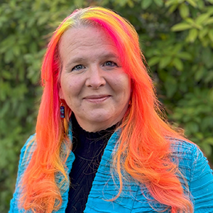 Headshot of Wanda Pratt with colorful highlights in their hair.