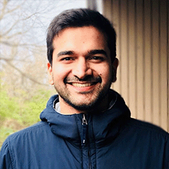 Anant Mittal, dressed in a blue coat and smiling warmly.