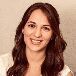 Yohali-Burrola-Mendez, a woman with long brown hair. She wears a white top and smiles at the camera.