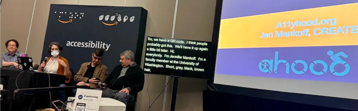 Joshua Miele, Jennifer Mankoff, and Ed Summers are 3 of 4 presenters on stage with captions on a monitor next to them and a projected image of the a11yhood.org logo.