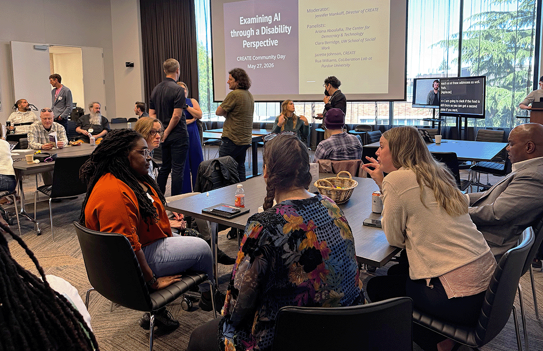 Photo of attendees seated or standing in casual discussion groups.