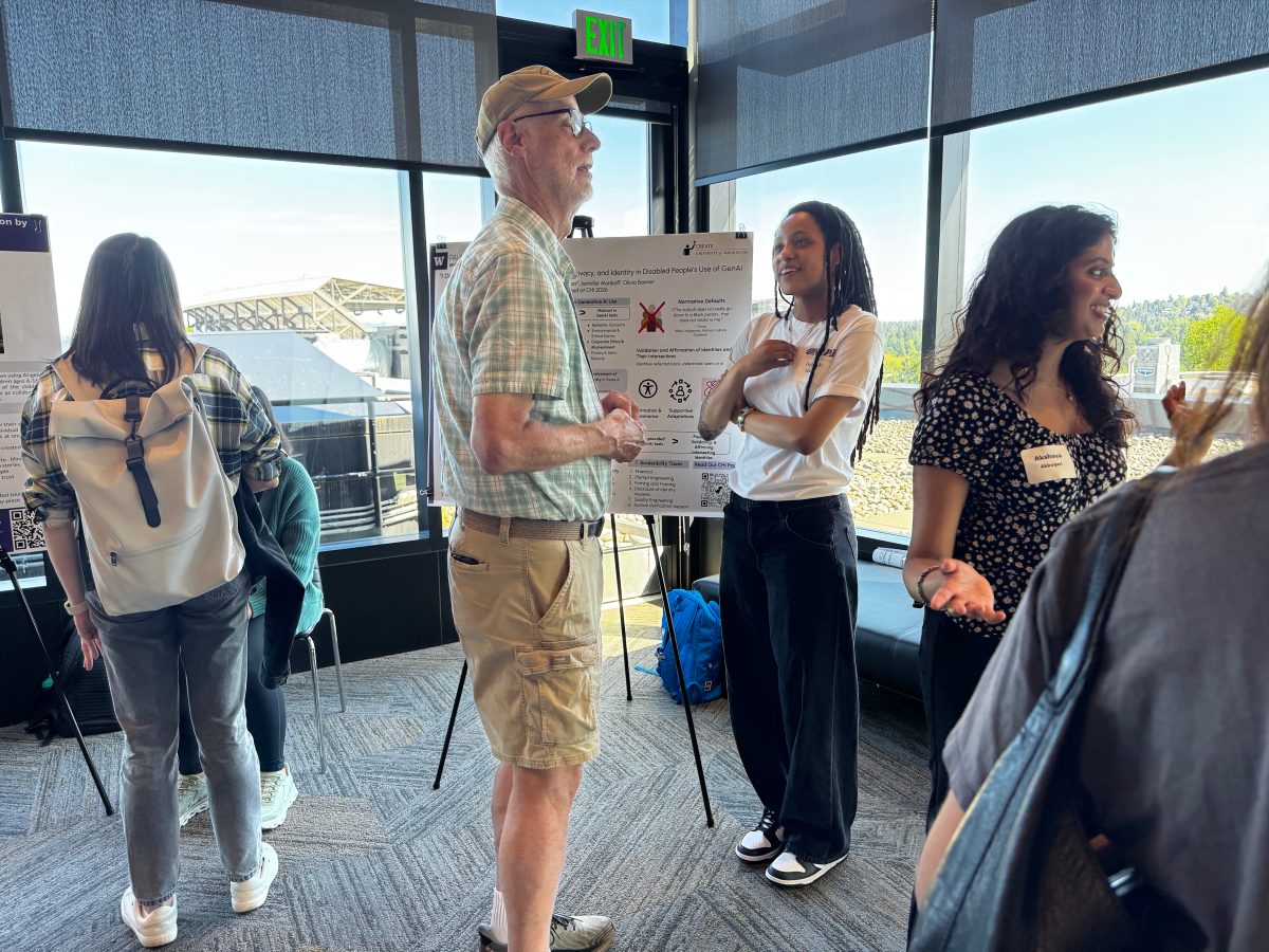 CREATE Ph.D. student Aaleyah Lewis chats with associate director Richard Ladner. They stand in front of Lewis' team poster, "'I Don't Trust It, But I Use It': Navigating Trust, Privacy, and Identity in Disabled People’s Use of Generative AI"