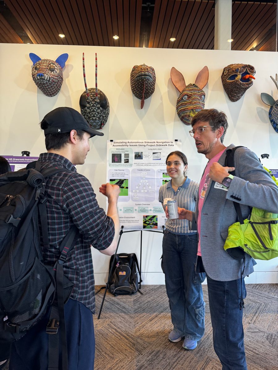 CREATE associate director Jon Froehlich chats with students. Masks displayed in the Zillow Commons are in the background.