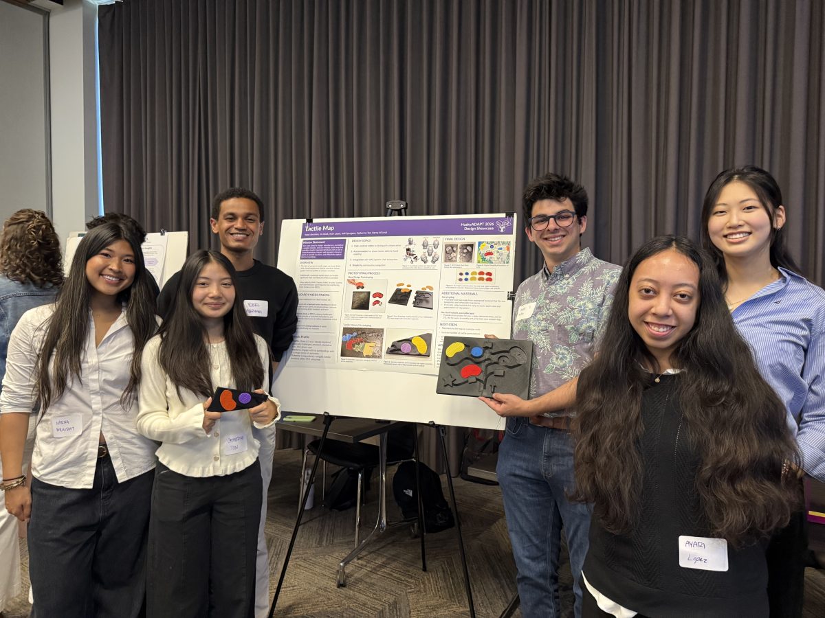 Tactile Map team poses in front of their poster with a prototype 3D printed map.