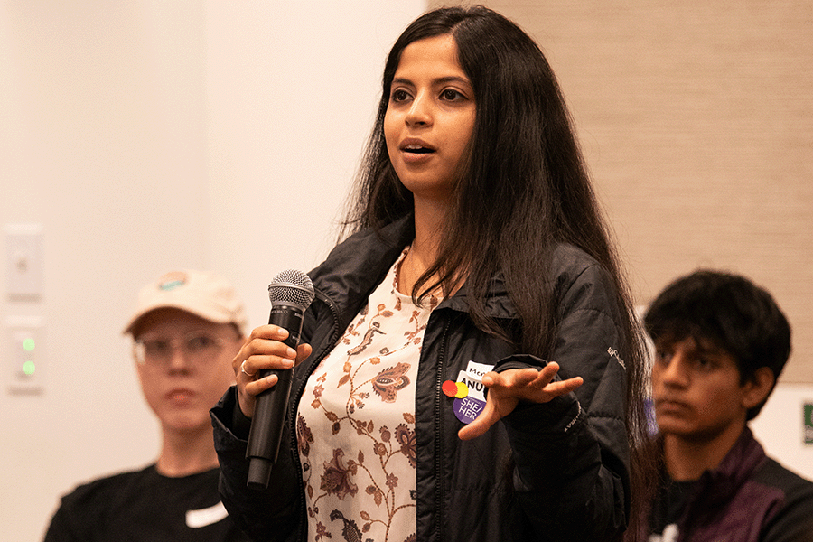 Anukriti Kumar introduces a workshop at CREATE Accessibility Hackfest - Summer 2026. She is standing amongst participants and holds a microphone.