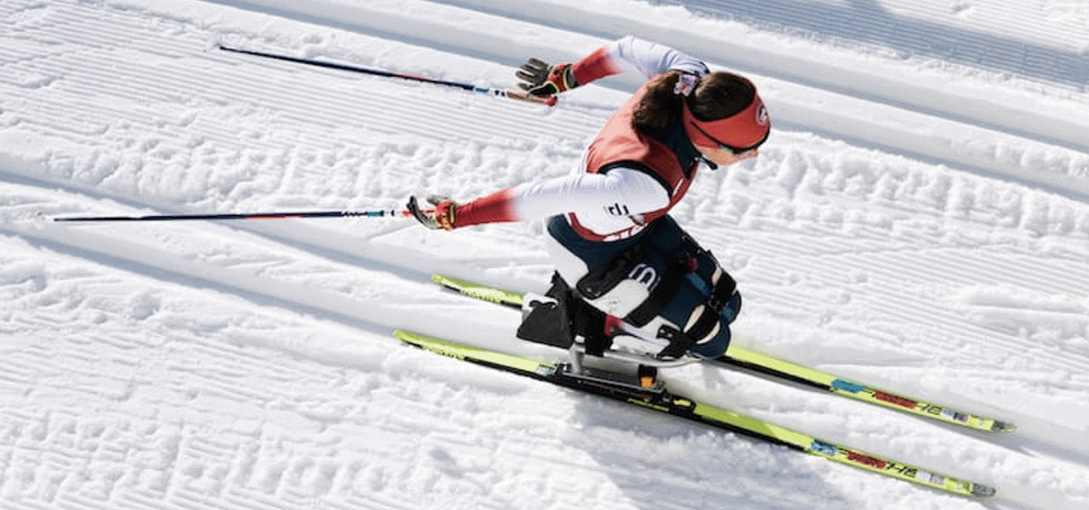 An overhead photo of Nicole Zaino using a sit-ski in a Para Nordic ski race