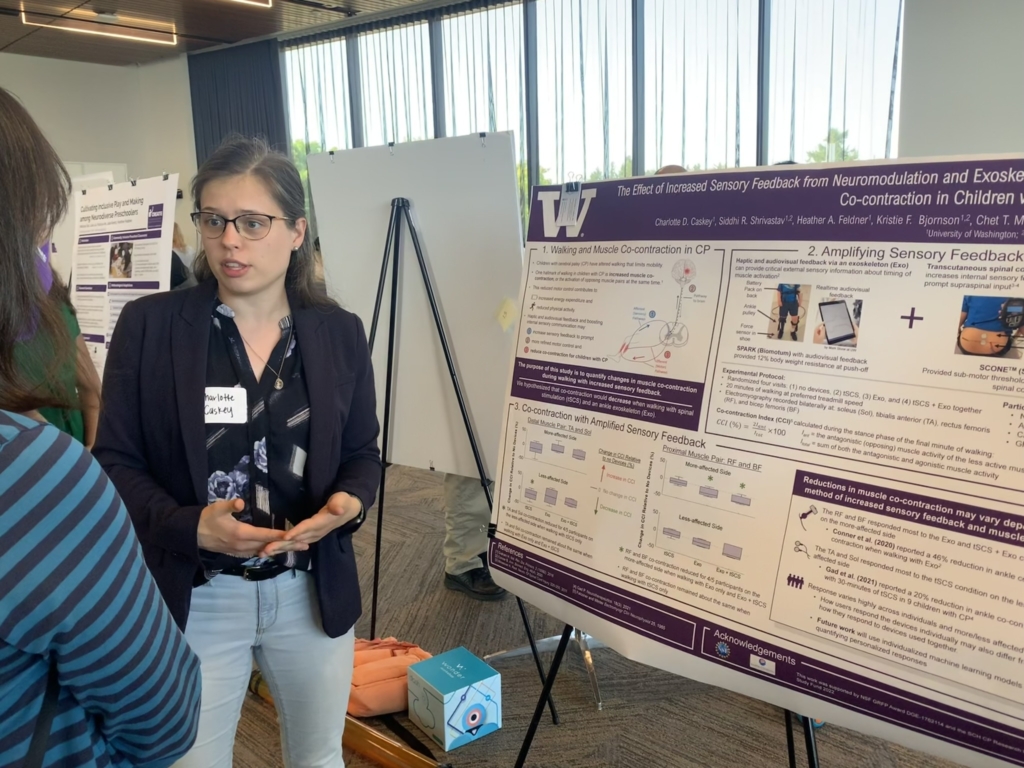 A student describes a poster to an attendee