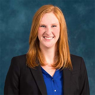 Headshot of Kim Ingraham. She has long ginger hair and is smiling into the camera.
