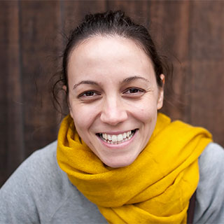 Headshot of Maya Cakmak She is smiling cheerfully and wearing a bright yellow scarf.