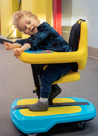 A child uses the Permobil Explorer Mini, a powered mobility device for children
