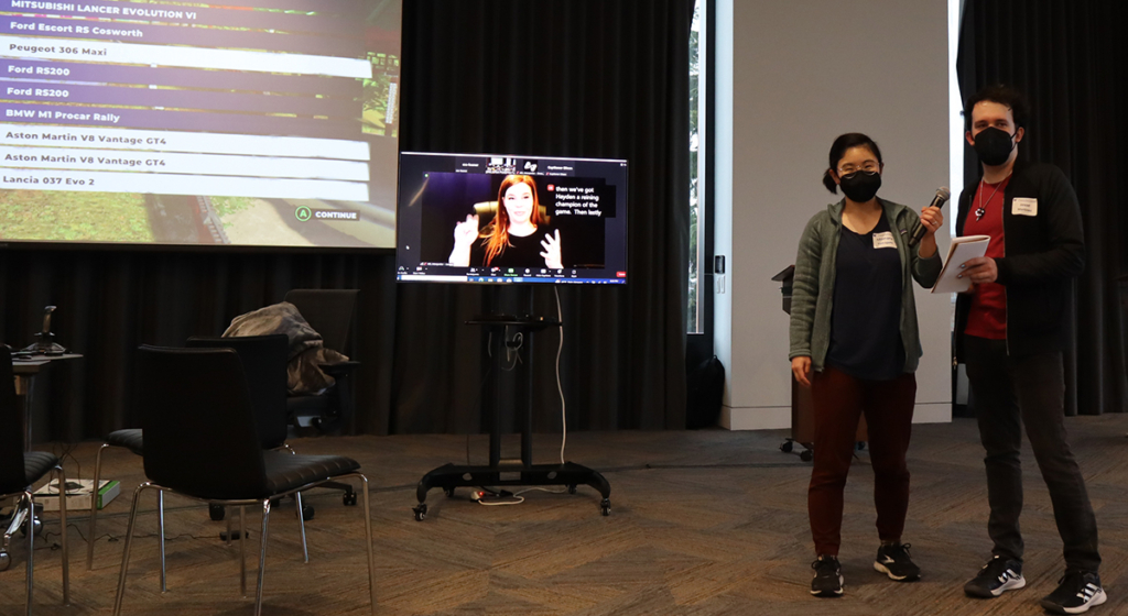 Momona Yamagami and Jesse Martinez open the Accessible eSports Showcase in front of a large screen with a dedicated screen showing a sign language interpreter.