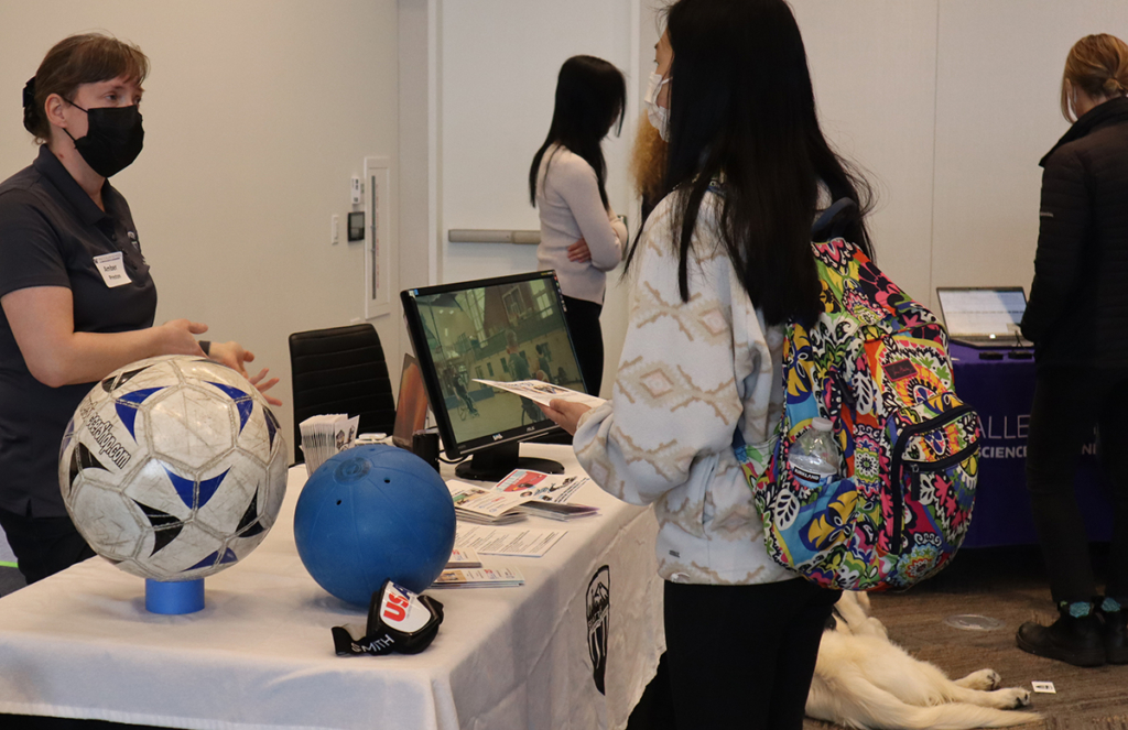 The Seattle Adaptive Sports table, with the different size balls used in games and a screen showing video of disabled athletes playing.