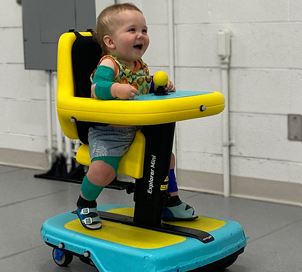 A joyful toddler on a Permobil Explorer Mini powered mobility device