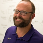 Jacob O. Wobbrock, a 40-something white man with short hair, a beard, and glasses. He is smiling in front of a white board.